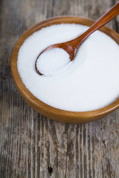 istock Sugar and spoon in a wooden bowl 621489296