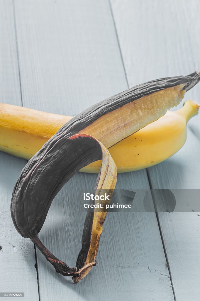 banane fraîche et pourrie sur fond de bois - Photo de Agriculture libre de droits