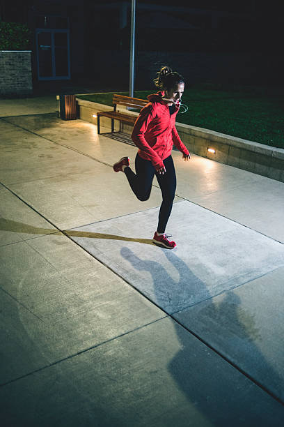 istock Female athlete running through the night 621493966