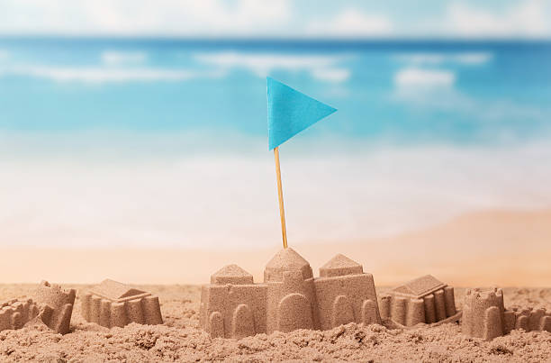 istock Castles made of sand and flag on background sea. 621497438