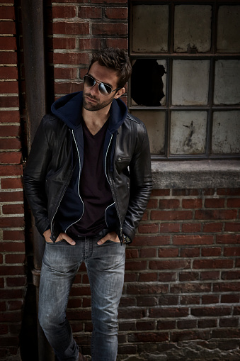 Man in jeans and leather jacket, looking away