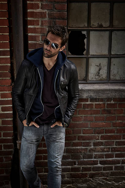 man in jeans and leather jacket, looking away - casaco de couro imagens e fotografias de stock