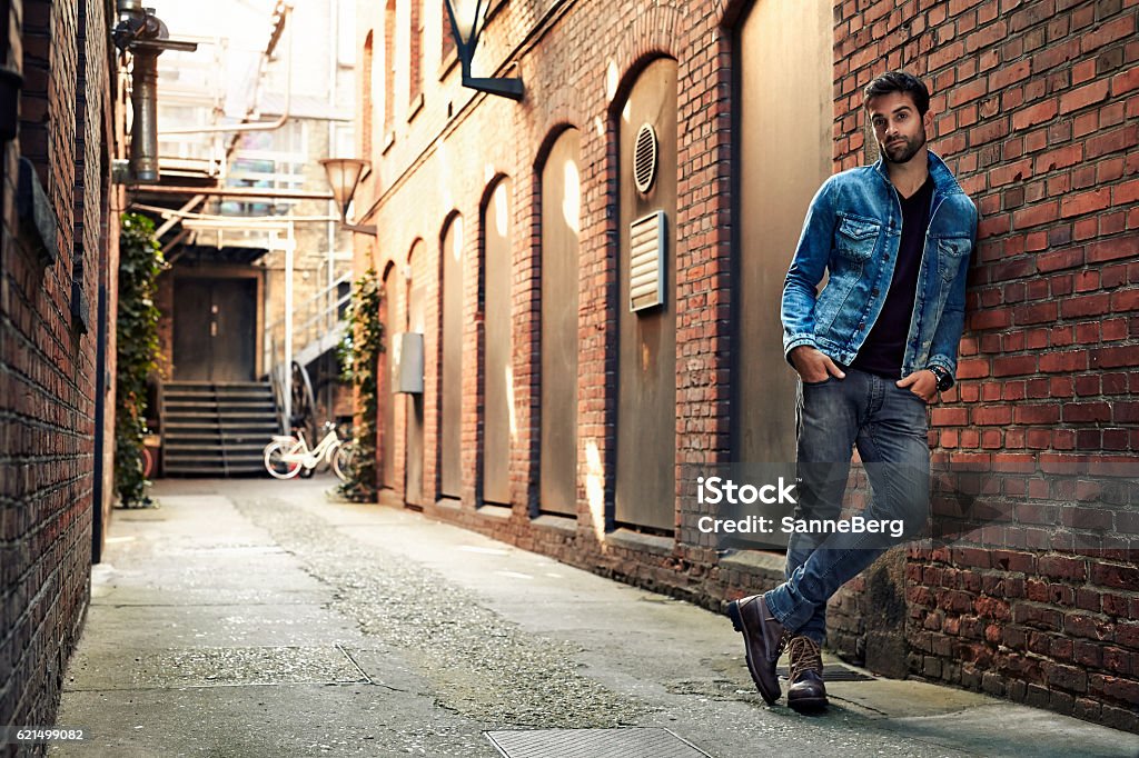 Man standing in street wearing denim, portrait Jeans Stock Photo