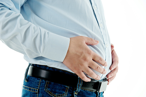 Primer plano de un hombre con sobrepeso sosteniendo su estómago photo