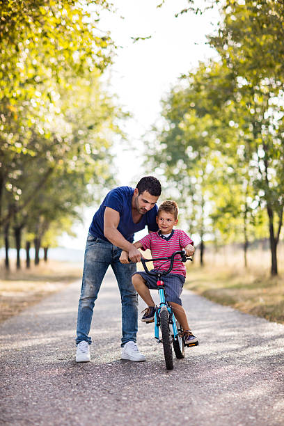 istock Father teaching his small son to ride bicycle in nature. 621501674