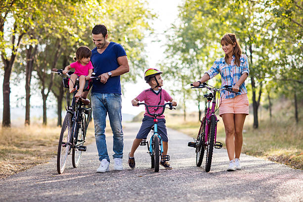 Happy parents enjoying with their small kid while riding bicycles at the park.