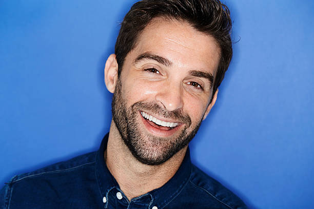 istock Happy smiling man in blue studio, close up 621502884