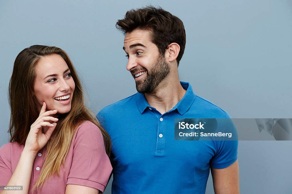Couple smiling at each other in polo shirts Couple - Relationship Stock Photo