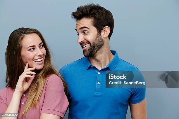 Couple Smiling At Each Other In Polo Shirts Stock Photo - Download Image Now - Couple - Relationship, Face To Face, Two People