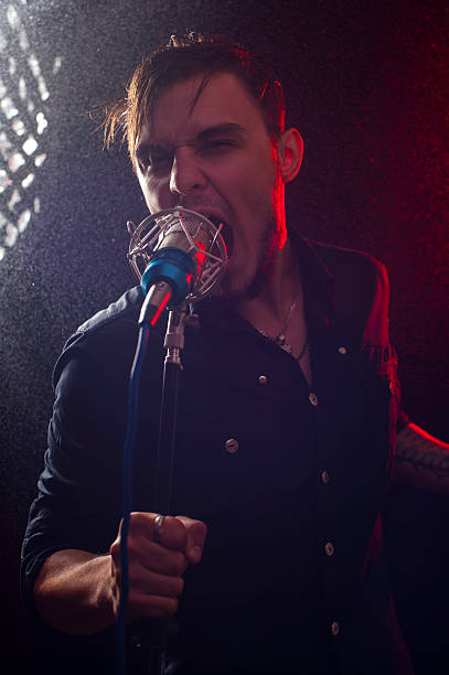 istock Portrait of expressive rock singer with microphone 621504536