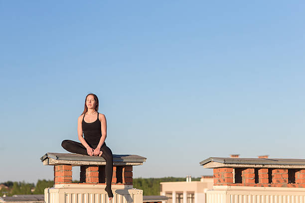 istock Young woman doing yoga on the roof 621504608