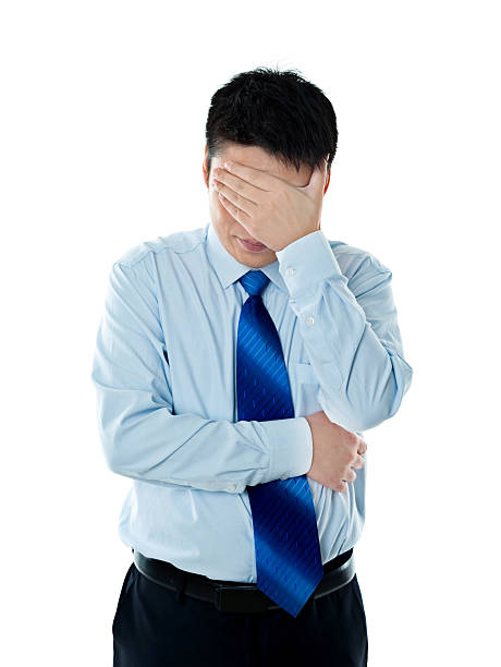 istock Disappointed young businessman covering eyes with hand 621504670