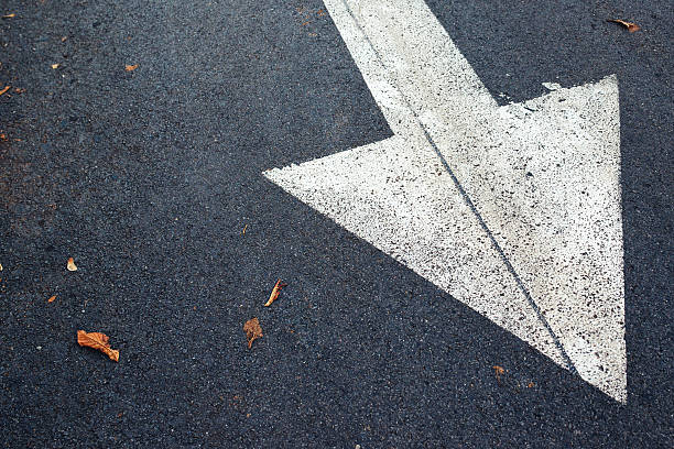 istock White arrow on asphalt road, traffic sign 621506038