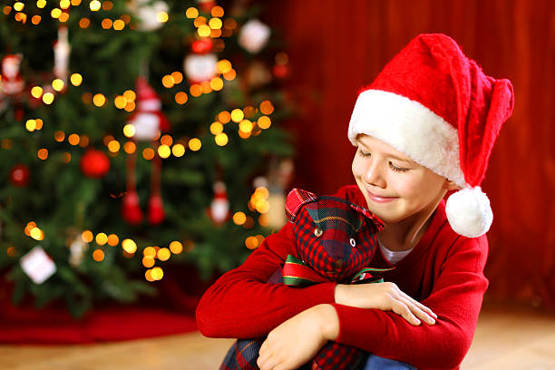 istock Happy Child with Santa Hat at a Christmas Tree 621506760