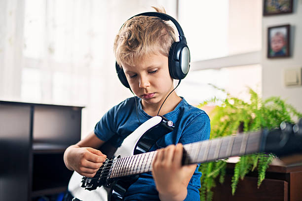 pequeño niño tocando la guitarra eléctrica - riff fotografías e imágenes de stock