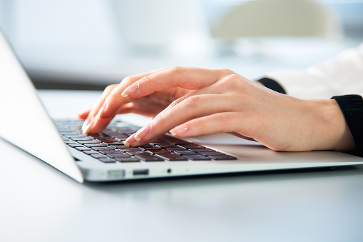 Closeup of businesswoman typing on laptop computer