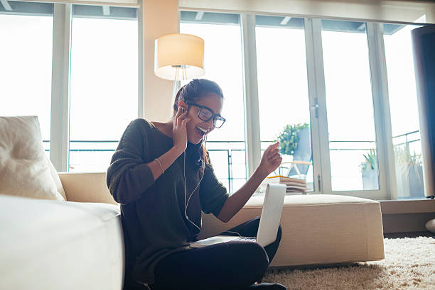 young woman using her laptop and singing