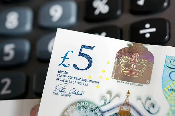 The new polymer five pound note with a calculator.