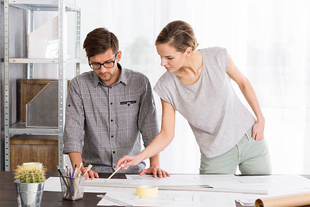 istock Woman is pointing something to her co-worker 621569322