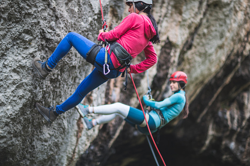A women rock climbers going down on the crag