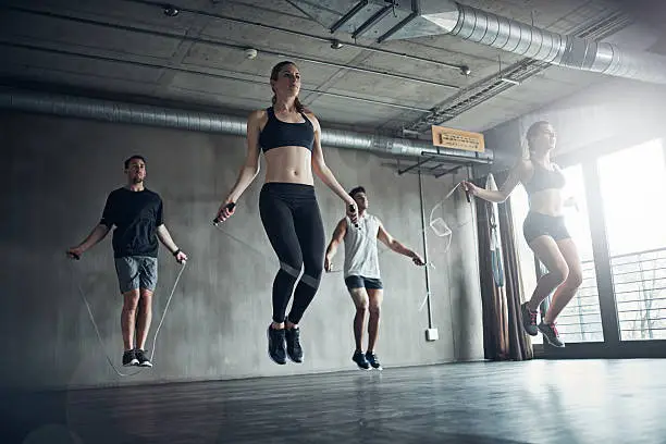 Shot of a fitness group training with jump ropes