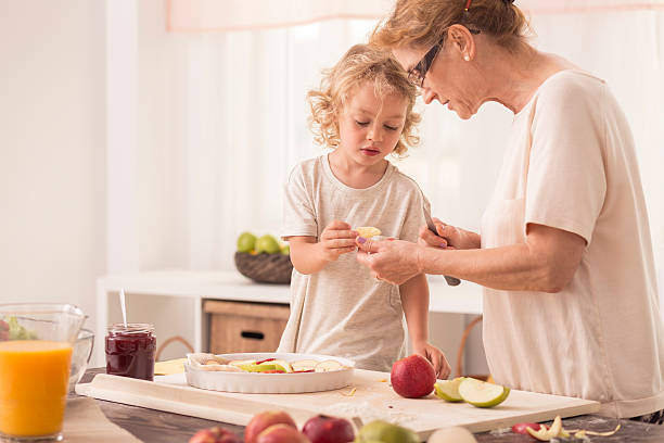 istock Child helping grandmother with baking 621571050
