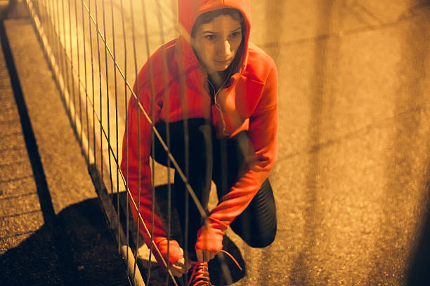 istock Female Athlete Tying her Shoes and Preparing Herself for Jogging 621571276