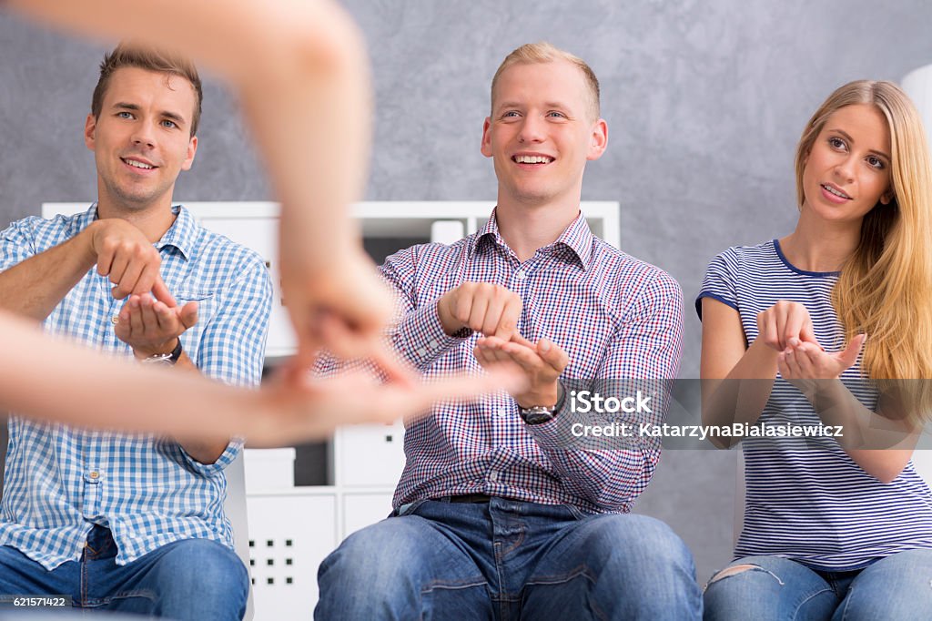 People repeating signs after their teacher Shot of a group of young people repeating signs after their teacher Learning Stock Photo