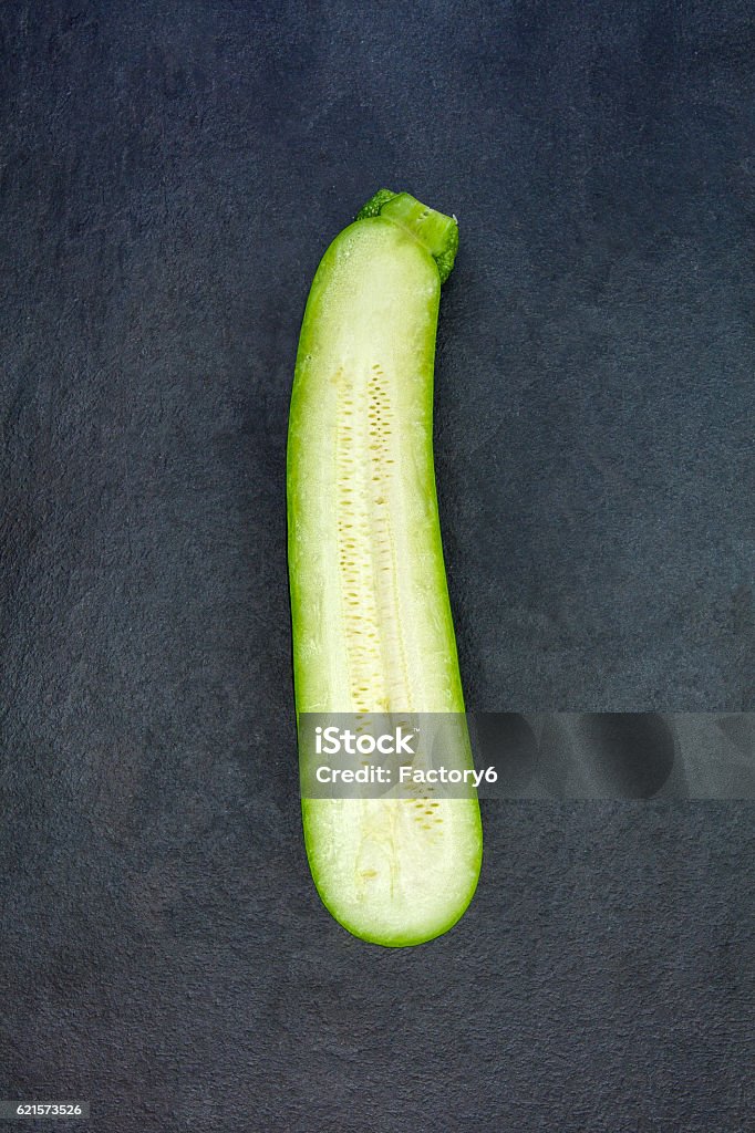 Deux moitiés de courgettes vertes fraîches isolées sur de l’ardoise grise - Photo de Aliment libre de droits