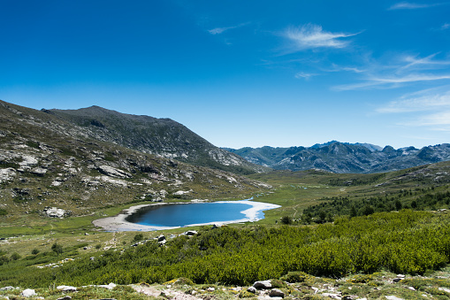 Rough mountain landscape with glacier lake against blue clear sky, Lac de Nino, Corsica, France