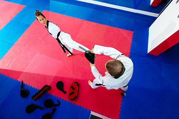 Focused sports woman with disability prepares for para-competition in taekwondo. Armless young adult, full of enthusiasm, exercising and working hard to achieve gold medal on upcoming global sport events in future.