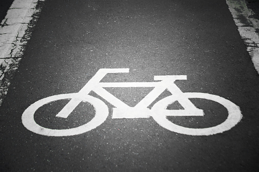 The sign of a bicycle on a street background process in vintage retro style.
