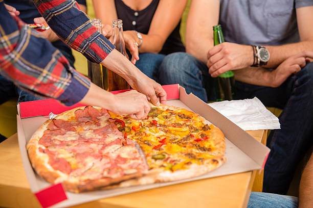 istock Group Of Friends Eating Pizza 621577074