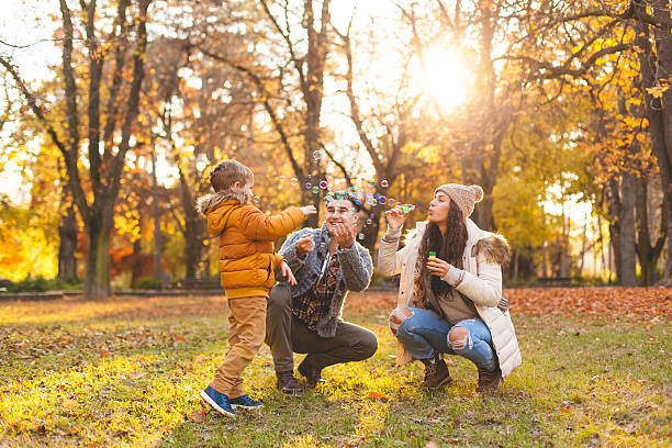 glückliche junge blasen blasen - family four people smiling autumn stock-fotos und bilder