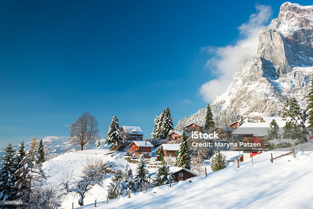 Christmas vacation in Europe. Travel to Switzerland in the winter. Alpine Village in the snow. Traditional houses with red shutters and roofs. Switzerland Stock Photo