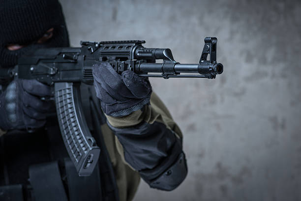 istock Soldier in balaclava with automatic rifle in hands 621580332