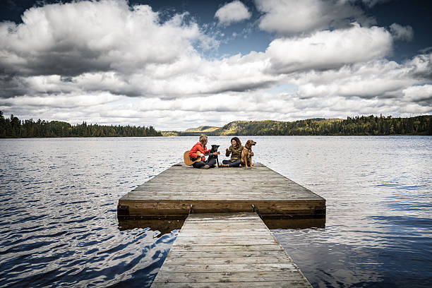 Couple enjoying a day playing guitar and relaxing outdoor in Algonquin Park, Ontario, Canada.