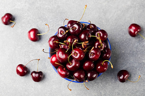 istock Fresh ripe black cherries in a black bowl Top view 621583142