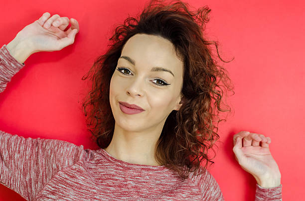 istock Beautiful young curly girl. Half-caste posing on a red backgroun 621583352