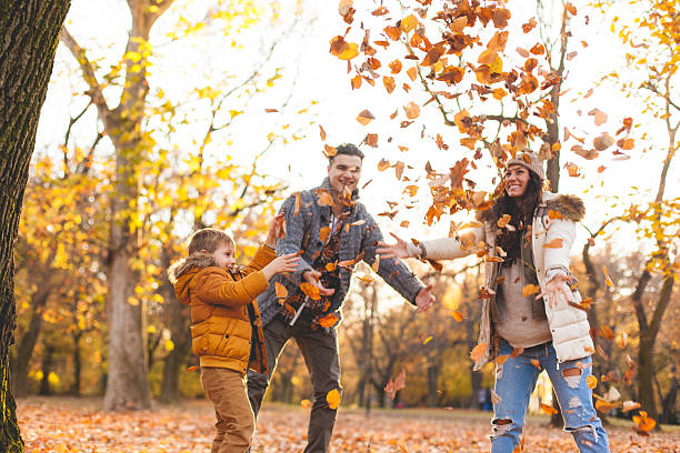 istock Family playing in autumn leaves 621583974