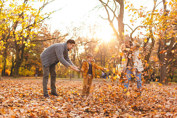 istock Family playing in autumn leaves 621584222