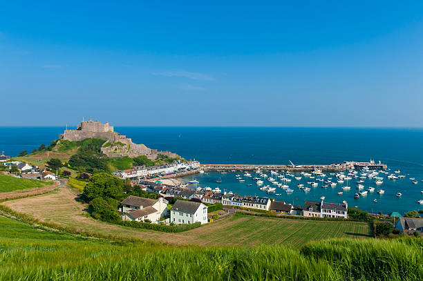 Harbour and Gorey Castle in Saint Martin Jersey Harbour and Gorey Castle in Saint Martin, Jersey, Channel Islands, UK on summer day. channel islands england stock pictures, royalty-free photos & images