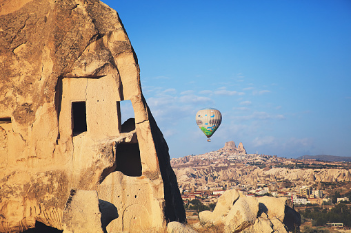 Nevsehir, Turkey - July 6, 2016: Tourists ride hot air balloon near the town of Uchisar on July 06, 2016 in Nevsehir, Turkey. Cappadocia, a historical region in Central Anatolia dating back to 3000 B.C is one of the most famous tourist sites in Turkey.
