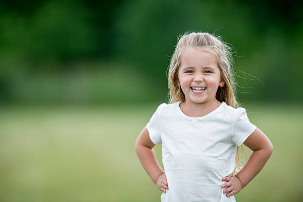 niña de pie afuera en el parque - t shirt child white portrait fotografías e imágenes de stock