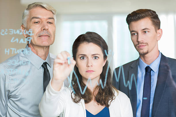 istock Serious Businesswoman Drawing Graph on Glass Screen 621590526