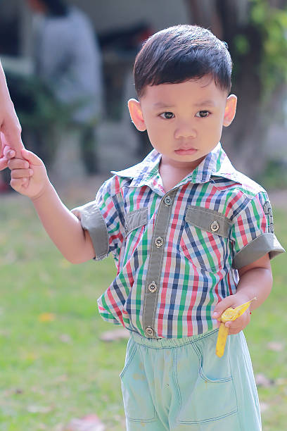 istock Lovely child  standing eat bananas 621593004