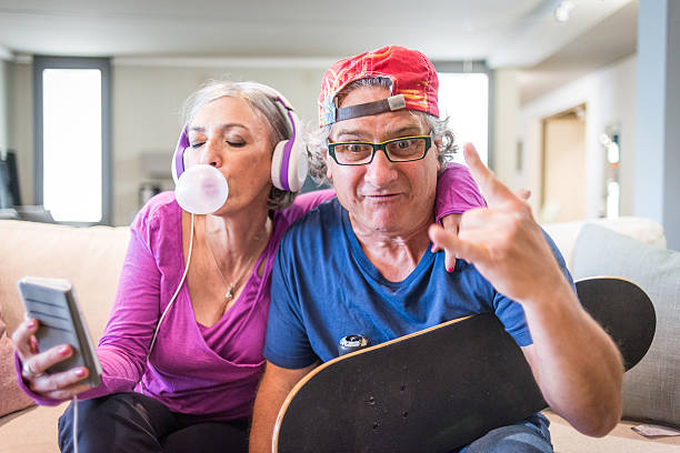 jóvenes abuelos serie : escuchando música y roca señal - senior couple audio fotografías e imágenes de stock