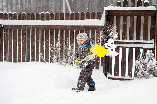 istock little boy cleans a shovel paths 621594278