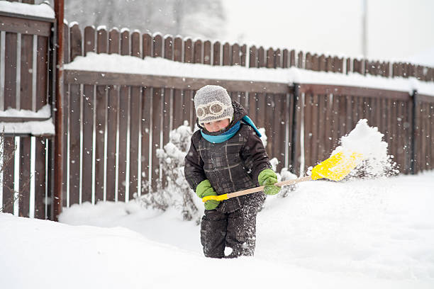 little boy cleans a shovel paths