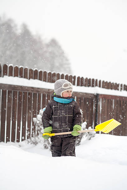 istock little boy cleans a shovel paths 621594394